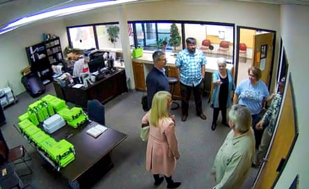 Screen shot from a Coffee county, Georgia, security camera at the Coffee county elections office showing a county Republican official, Cathy Latham, in a long light blue shirt, with a team of computer specialists that created copies of voting equipment data in January 2021.